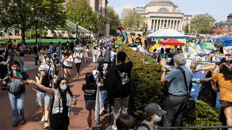 Student protesters march round their encampment on the Columbia University...