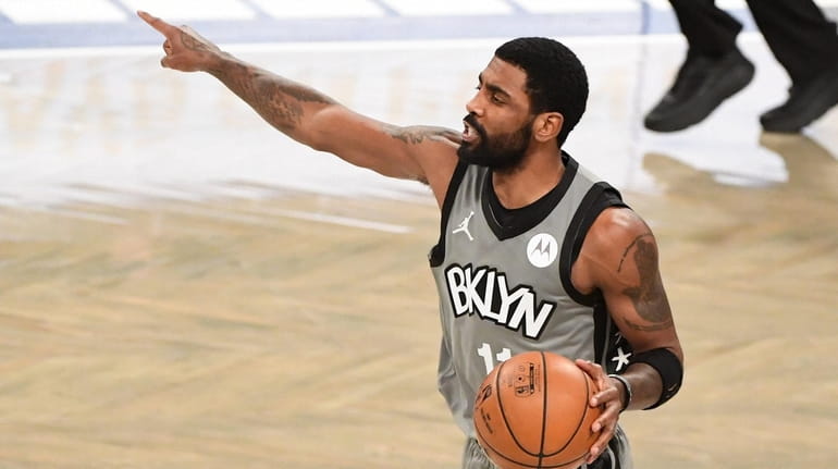 Nets guard Kyrie Irving directs his teammates against the Washington...