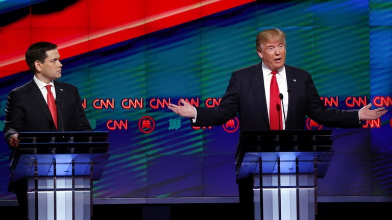 Republican presidential candidate Donald Trump, right, answers a question as...