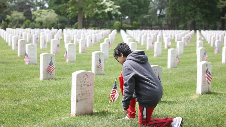 Matthew Carvajal, 13, of Centereach, prays at the gravesite of...