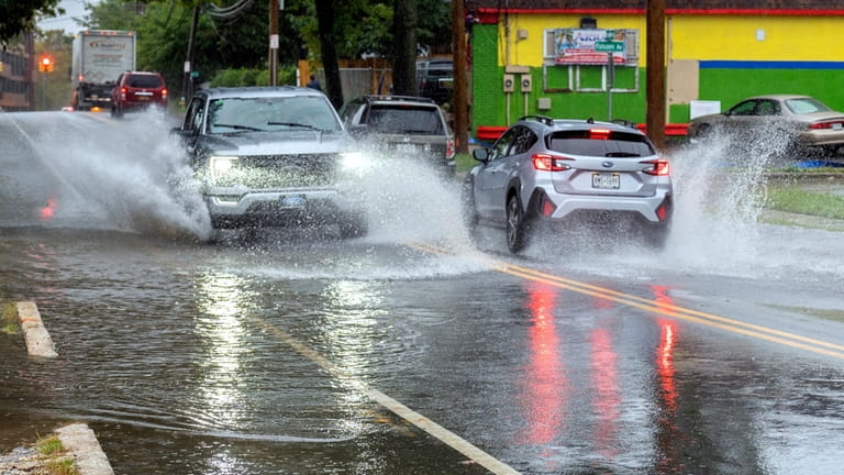 Cars splash along Broadway in Huntington Station on Friday.