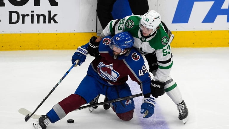 Colorado Avalanche defenseman Samuel Girard (49) gets tangled up with...