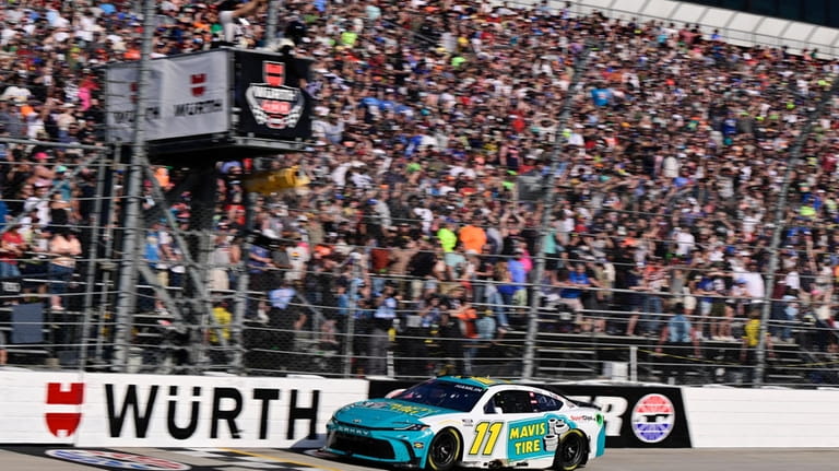 Denny Hamlin crosses the finish line to win a NASCAR...