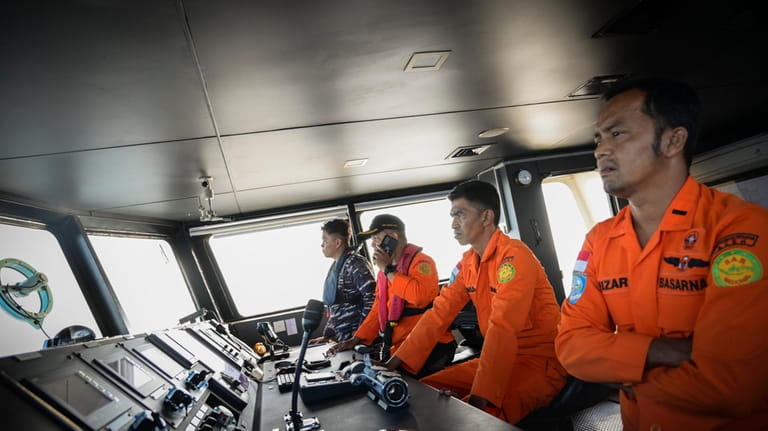 Members of Indonesia's National Search and Rescue Agency scan the...