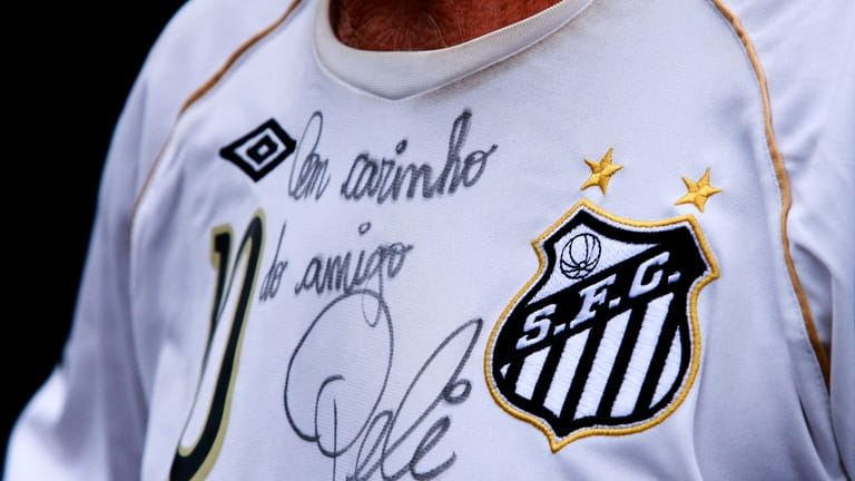 A fan wears a soccer jersey autographed by soccer legend...