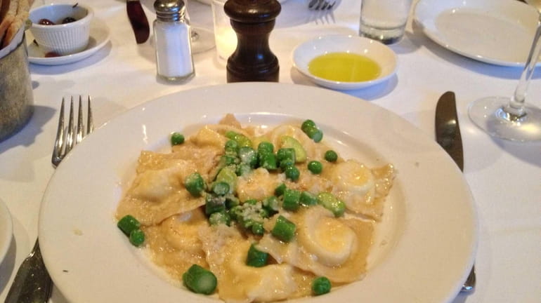 Ricotta ravioli are served with spring vegetables and browned butter...