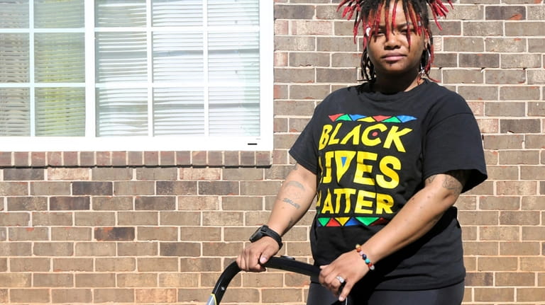 Nia Thomas stands in front of her Atlanta home on...