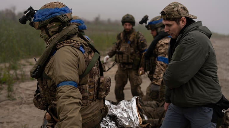 Ukrainian servicemen evacuate injured comrade at the frontline close to...