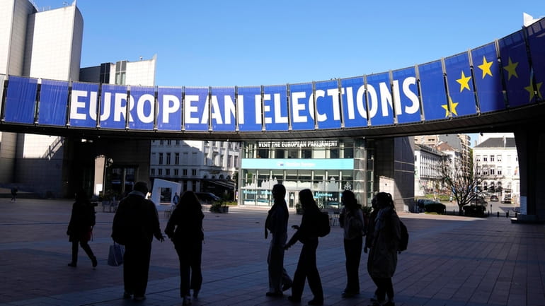 A group stands under an election banner outside the European...