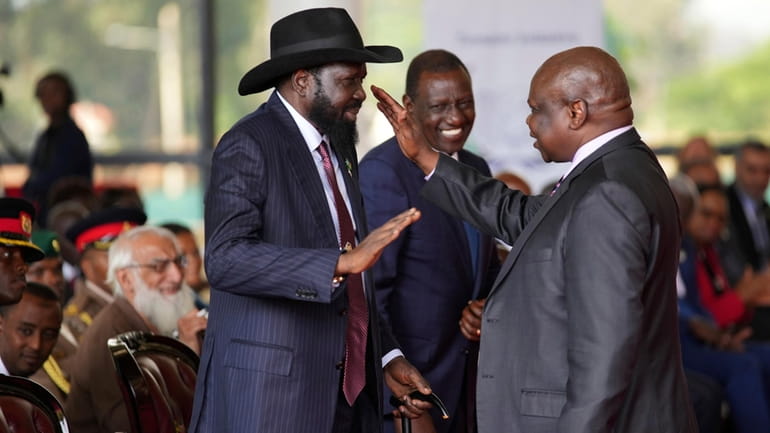 South Sudanese president Salva Kiir, left, shakes hands with Pagan...