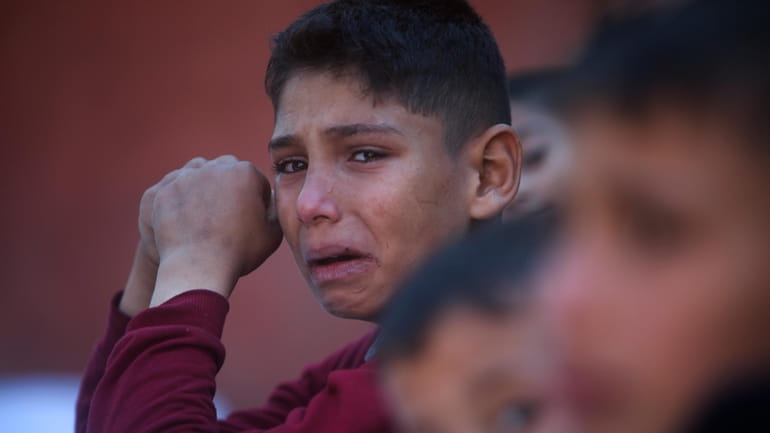 A Palestinian boy cries for his relatives who were killed...