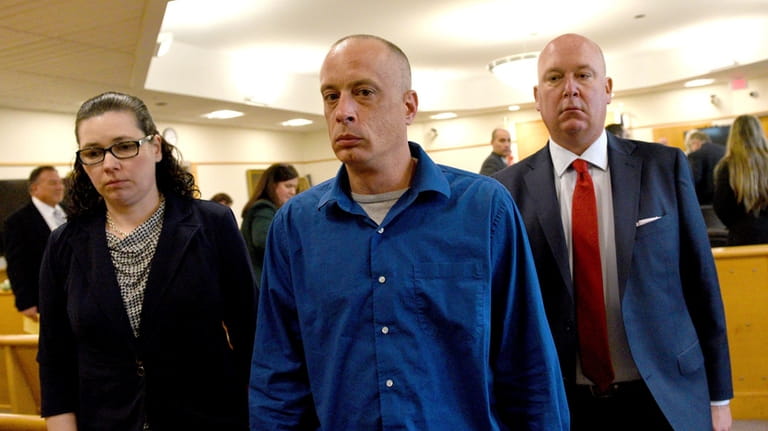 David Meehan, center, walks out of the courtroom with his...