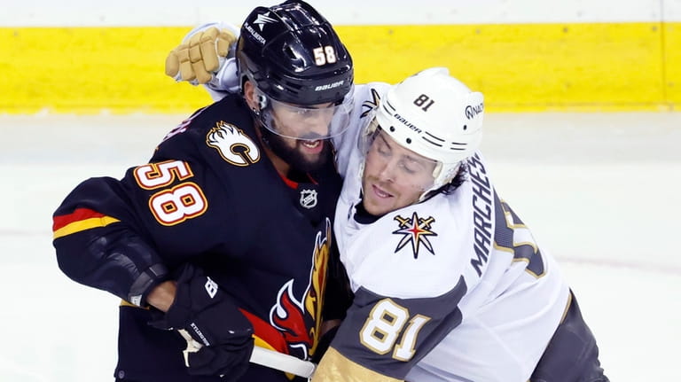 Vegas Golden Knights' Jonathan Marchessault, right, grabs Calgary Flames' Oliver...