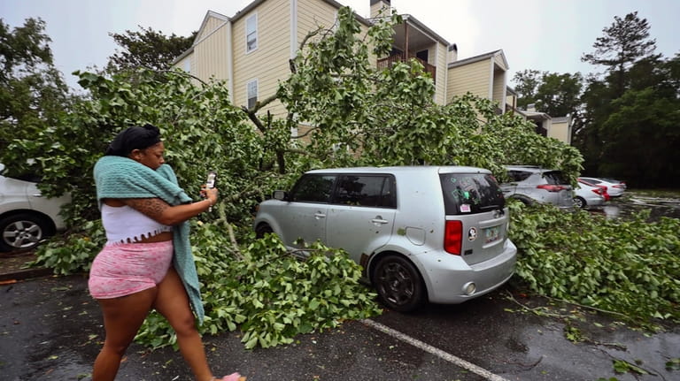 A resident records the damage to cars outside an apartment...