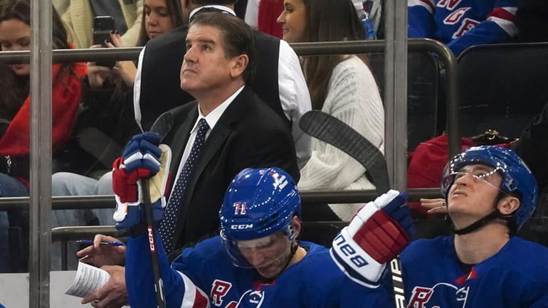 Rangers' head coach Peter Laviolette, left, looks up at the...