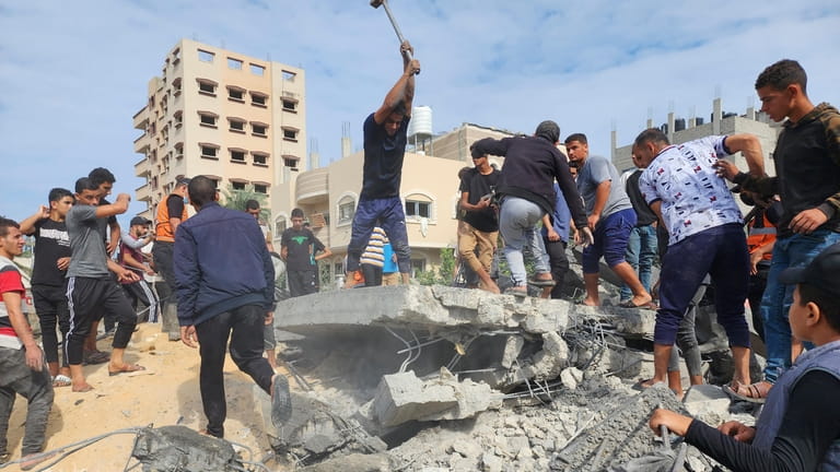 Palestinians look for survivors in buildings destroyed by Israeli airstrikes...
