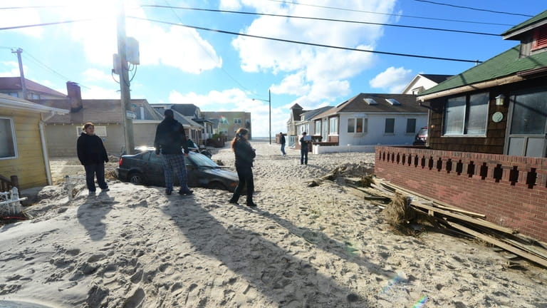 Long Beach residents assess the damage caused by Sandy and begin...
