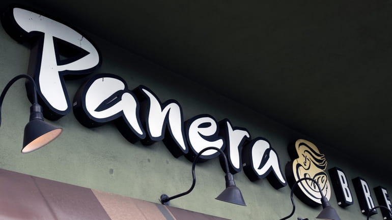 A Panera Bread sign and logo is attached to the...