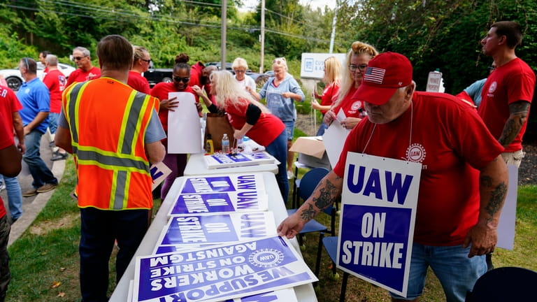 United Auto Workers members and supporters picket outside a General...