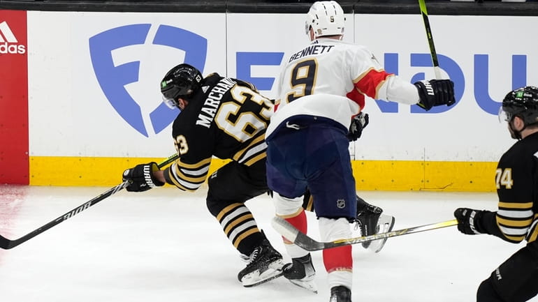 Florida Panthers' Sam Bennett (9) checks Boston Bruins' Brad Marchand...
