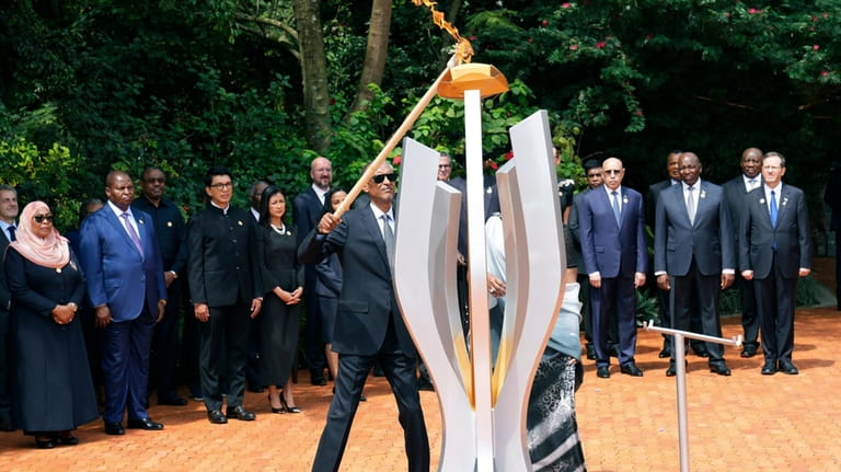 Rwandan President Paul Kagame lights a memorial flame during a...