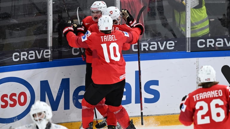Switzerland's Thierry Schild celebrates scoring with teammates during the IIHF...