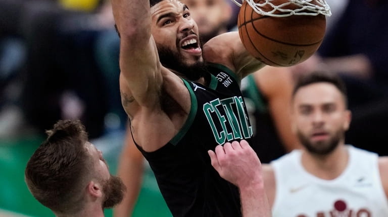 Boston Celtics forward Jayson Tatum, center, dunks against Cleveland Cavaliers...