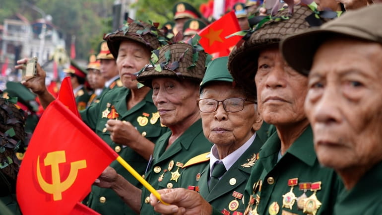 Veterans watch a parade commemorating the victory of Dien Bien...
