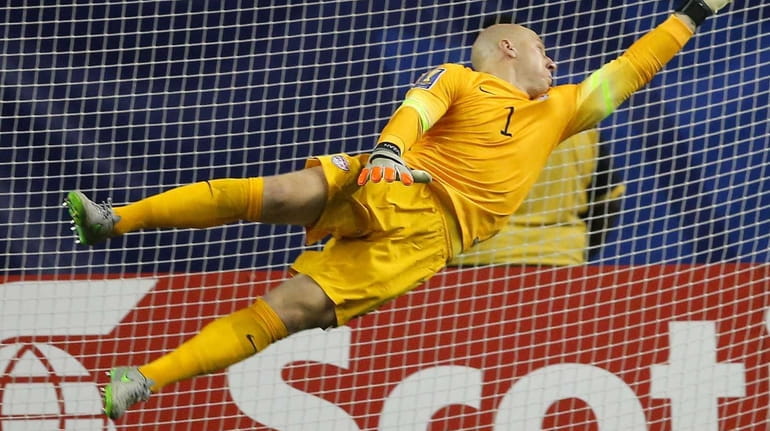 The ball gets past United States goalkeeper Brad Guzan for...