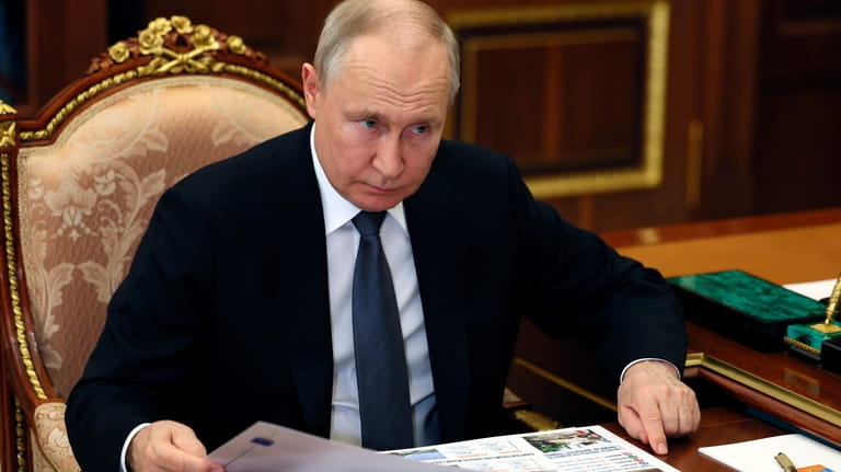 Russian President Vladimir Putin listens to Saratov region Governor Roman...