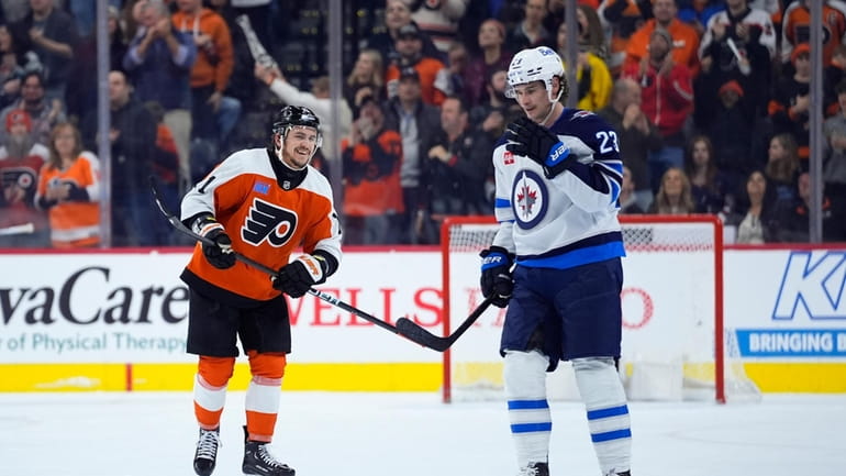 Philadelphia Flyers' Travis Konecny, left, reacts past Winnipeg Jets' Sean...