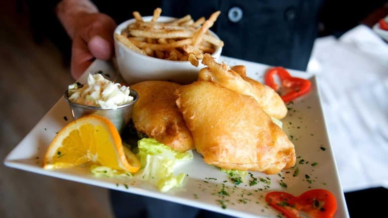 A platter of beer-battered catfish and chips is served at...