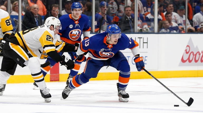 Islanders center Mathew Barzal goes for the puck on Penguins...