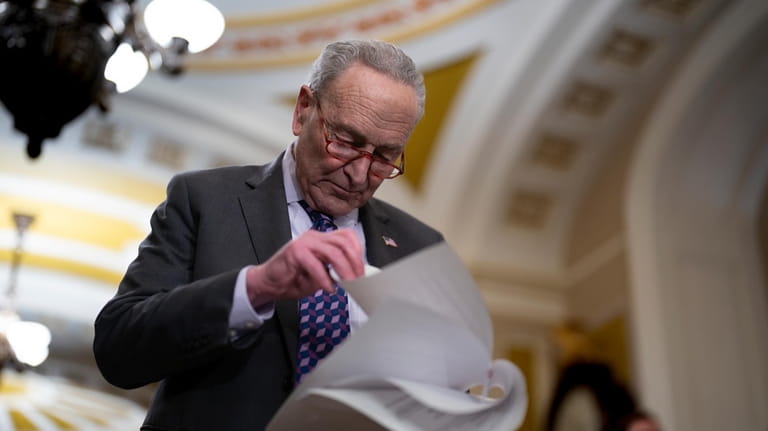 Senate Majority Leader Chuck Schumer, D-N.Y., looks over papers before...