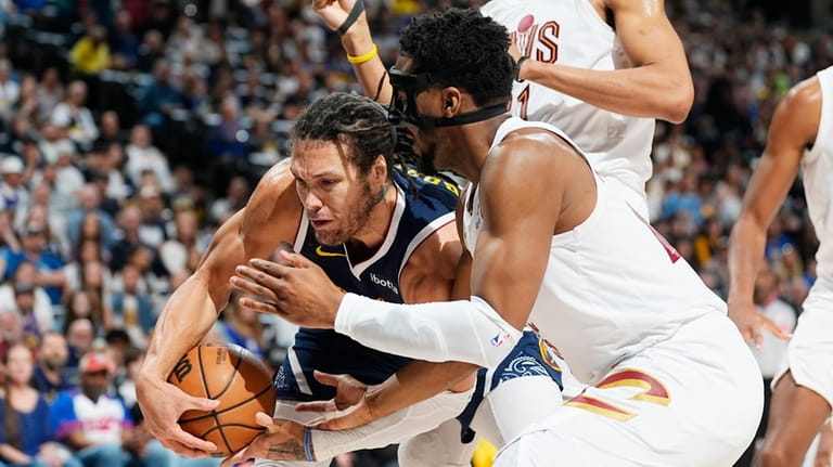 Cleveland Cavaliers guard Donovan Mitchell, right, battles for control of...