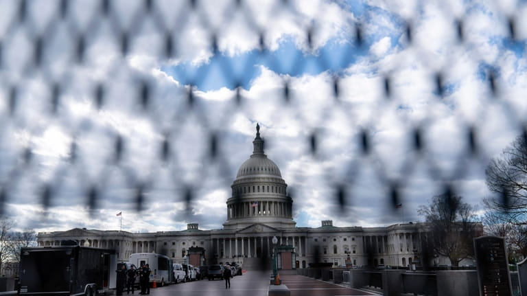 The U.S. Capitol is seen behind a security fence on...