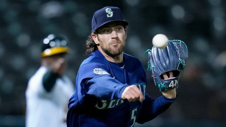 Mariners relief pitcher Penn Murfee throws to first for an...