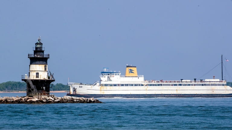 The Cross Sound Ferry passes by the Orient Point Lighthouse,...