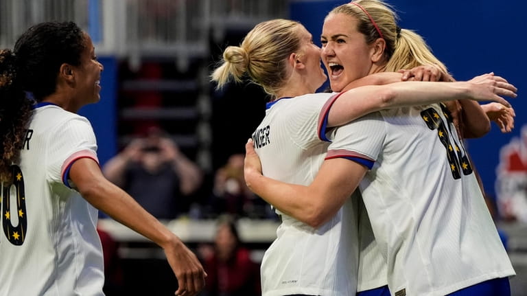 United States' Lindsey Horan, right, celebrates with teammates after scoring...