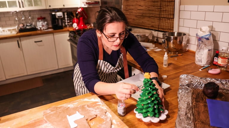 Catherine Manett puts the finishing touches on a gingerbread Christmas...