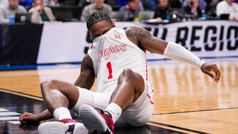 Houston's Jamal Shead reacts after going down while driving to...