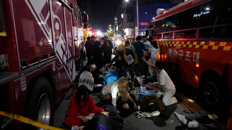 Injured people are helped at a street near the scene...