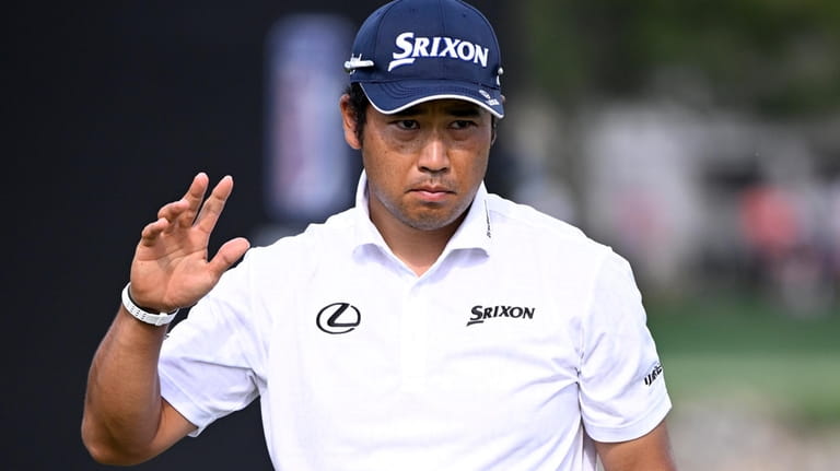 Hideki Matsuyama, of Japan, acknowledges the crowd after making a...
