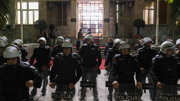 Montenegro police officers guard parliament building during a protest against...
