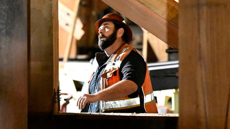A construction worker looks up at the I-10 freeway, which...