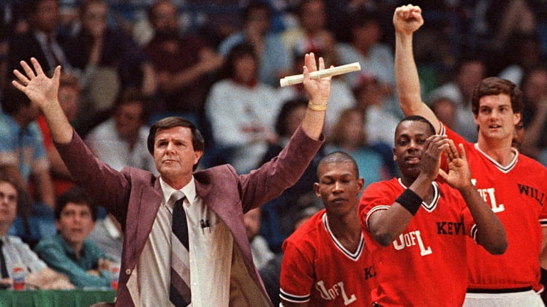Louisville coach Denny Crum gestures towards his team as players...