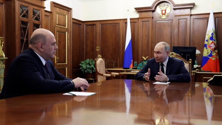 Russian President Vladimir Putin, right, speaks to Mikhail Mishustin, the...