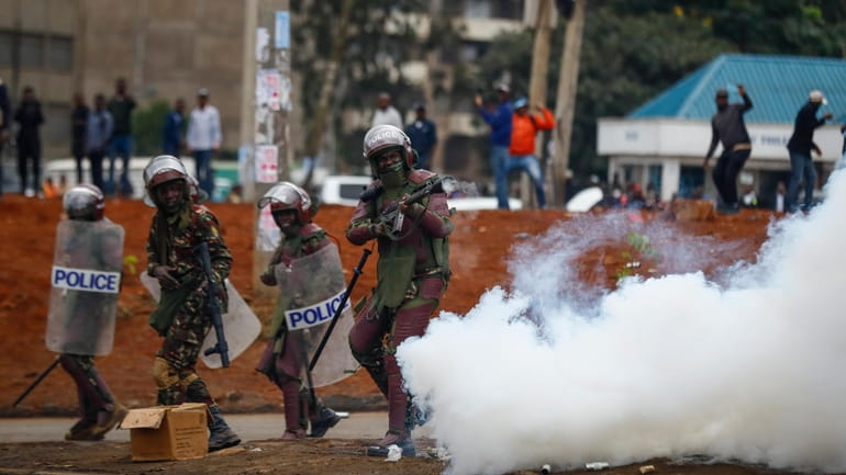 Riot police fire tear gas grenades at demonstrators during protests...