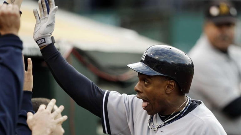 Yankees' Curtis Granderson celebrates in the dugout after his two-run...