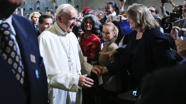 Pope Francis greets attendees as he leaves an interfaith prayer...